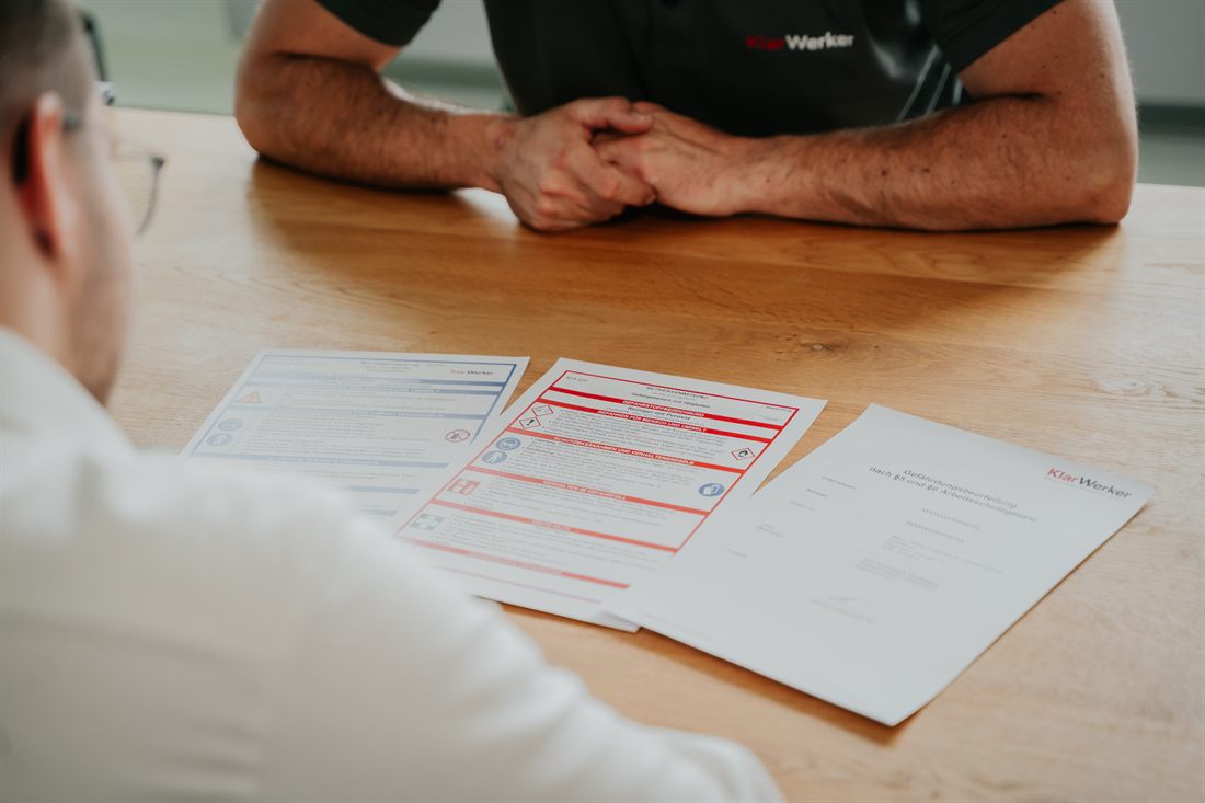 Sicherheitsunterlagen und Dokumentation zur Gefährdungsbeurteilung werden am Tisch durchgearbeitet